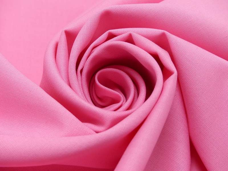 rosa-baumwollstoff Close-up of pink fabric twisted into a spiral rose shape.